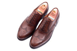 Eleganckie obuwie koloru brązowego z dekoracyjnymi zdobieniami typu brogues z gumową podeszwą. Szyte metodą ramową.