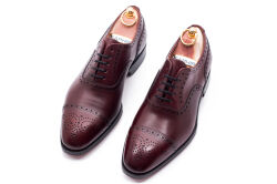 Eleganckie obuwie koloru bordowego typu brogues z skórzaną podeszwą. Szyte metodą ramową.