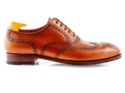 Eleganckie obuwie koloru jasno brązowego typu brogues z skórzaną podeszwą. Szyte metodą ramową.