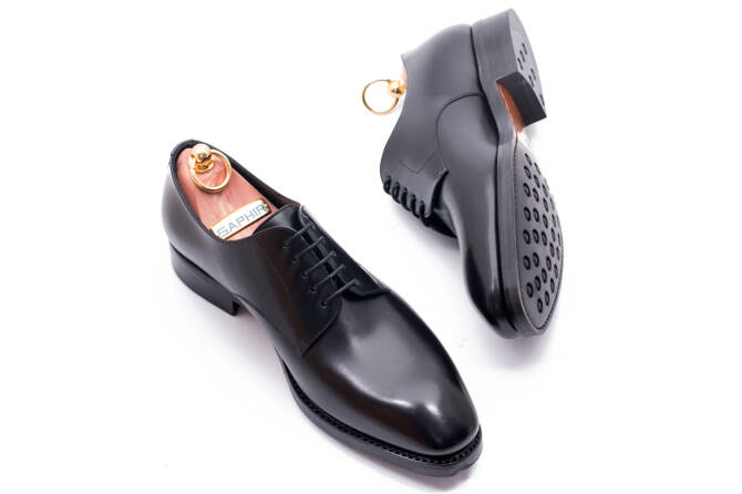 Czarne licowe buty typu derby z otwartymi obłożynami.  Bluchers. Buty wizytowe o mniejszym stopniu formalności.  Plain derby. 