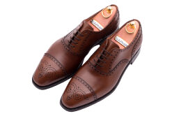 Eleganckie obuwie koloru brązowego typu brogues z skórzaną podeszwą. Szyte metodą ramową.